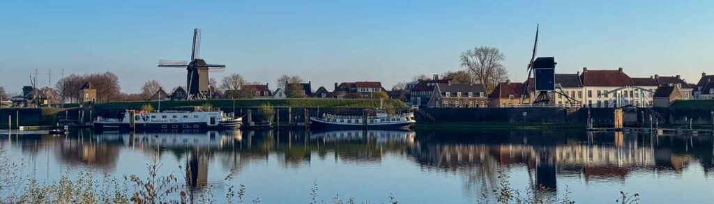 Panorama van Heusden met twee molens en een mooie reflectie in het water
