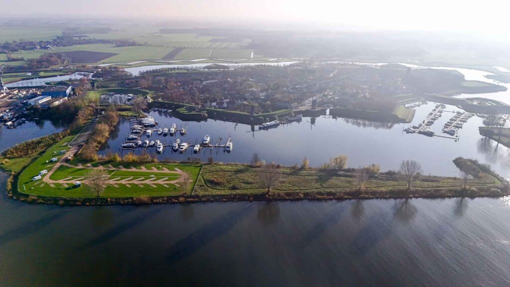 Dronefoto van de camperplaats met daarachter het vestigingsstadje Heusden in Nederland