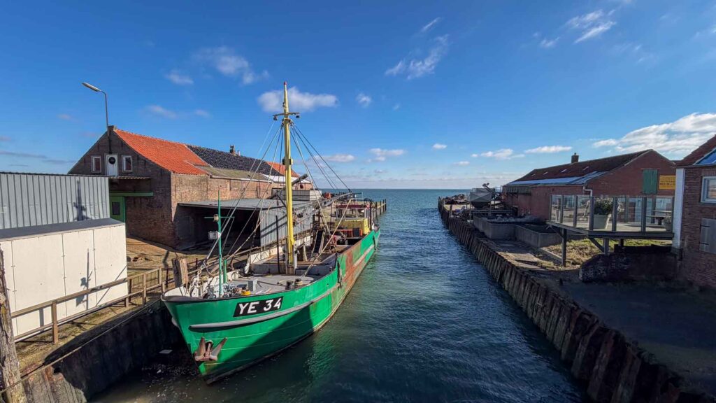 Boot langs de kade in Yerseke tussen de oesterrestaurants en winkels