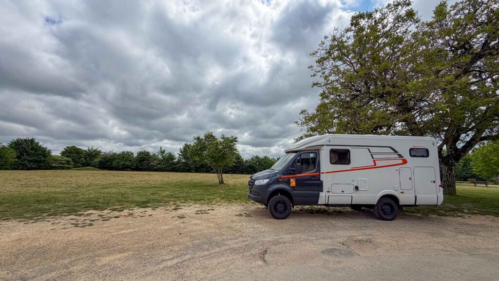 De Hymer ML-T 570 geparkeerd onder een boom op het grasveld tijdens de lunchstop in Romagne op de Marokko camperreis 2026
