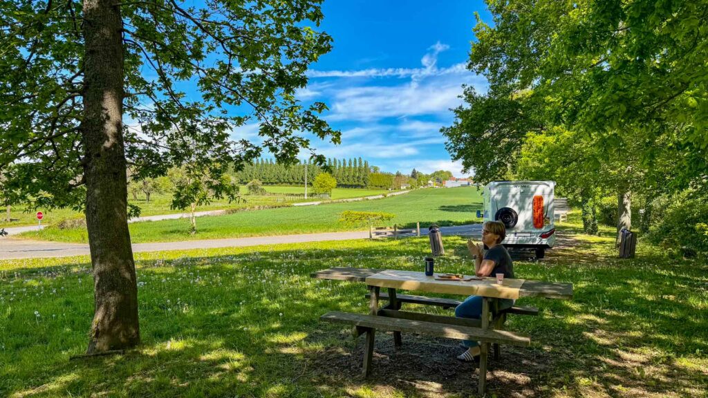 Jeannette aan de picknicktafel in Tourouvre-au-Perche met de Hymer ML-T 570 en uitzicht op de achtergrond tijdens de Marokko camperreis 2026