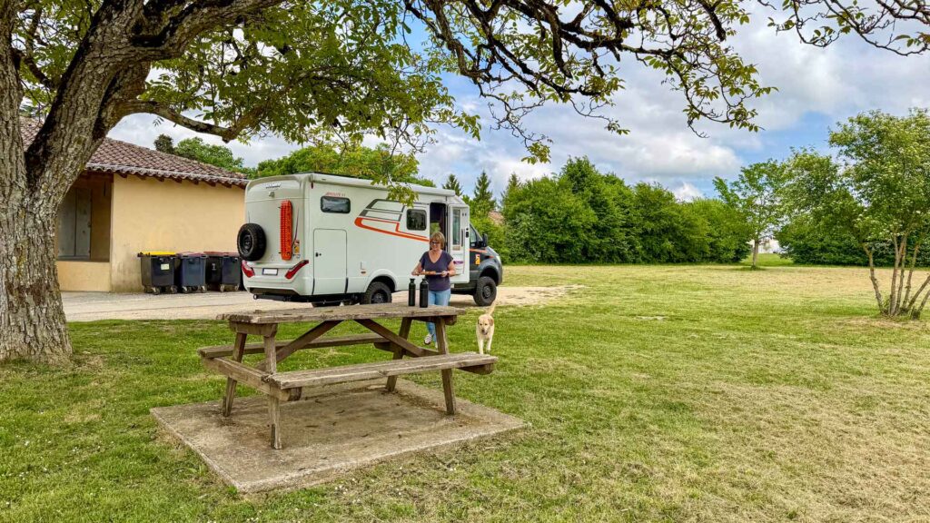 Jeannette en Stella komen aan met het eten bij de picknicktafel tijdens de lunchstop in Romagne op de Marokko camperreis 2026