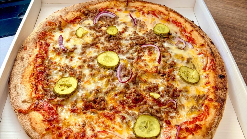 Pizza burger uit de pizza-automaat onderweg naar Pau tijdens de Marokko camperreis 2026